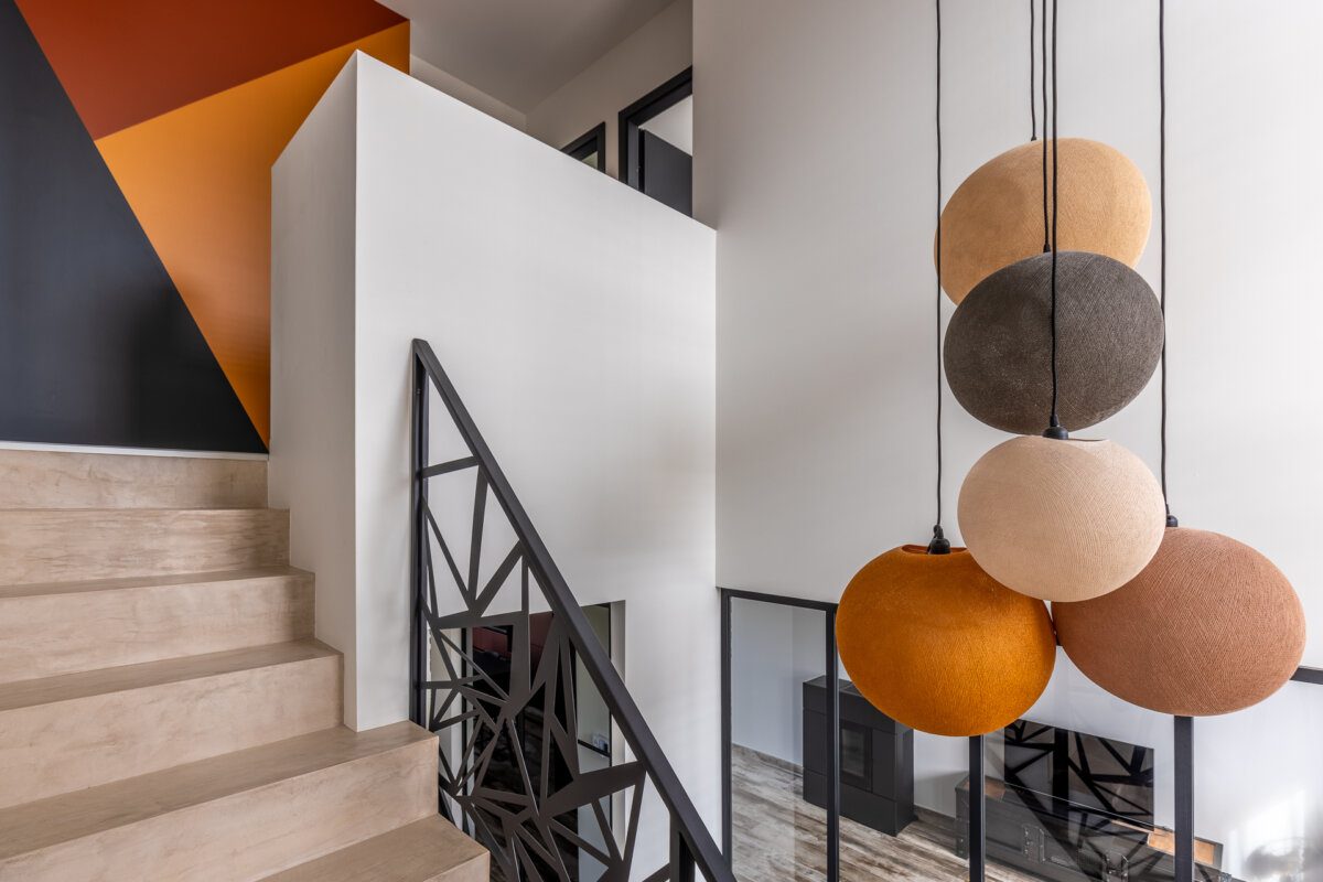 Montée d'escalier, mur terracotta et suspensions