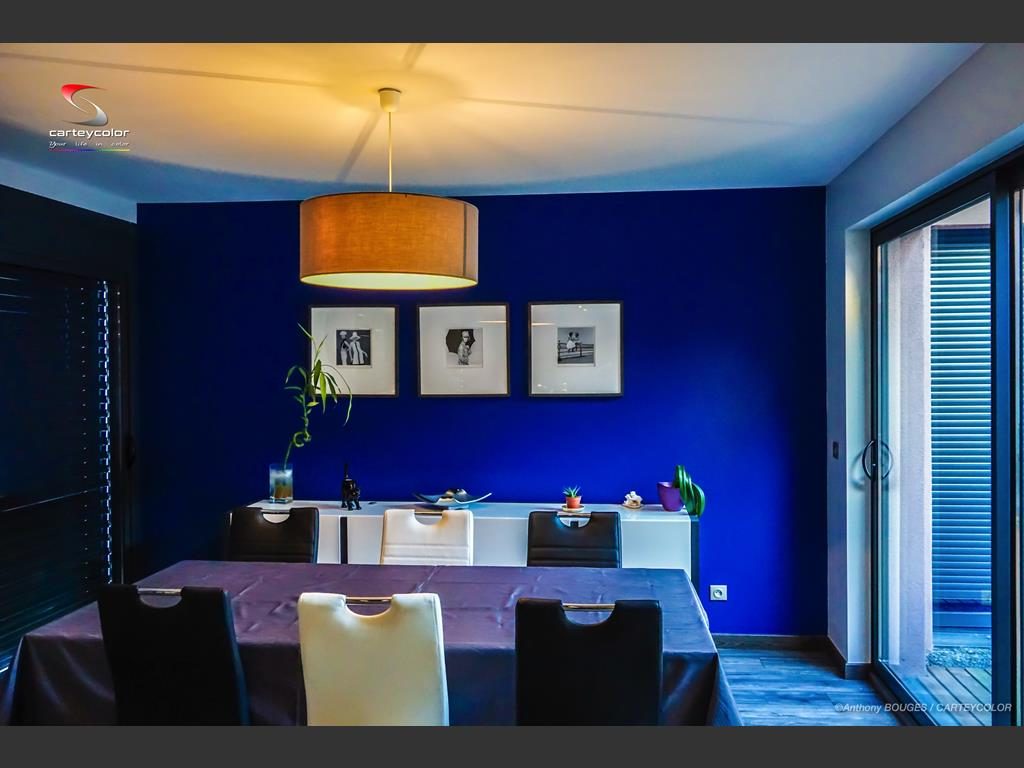 Salle à manger au mur bleu nuit, suspension orangée